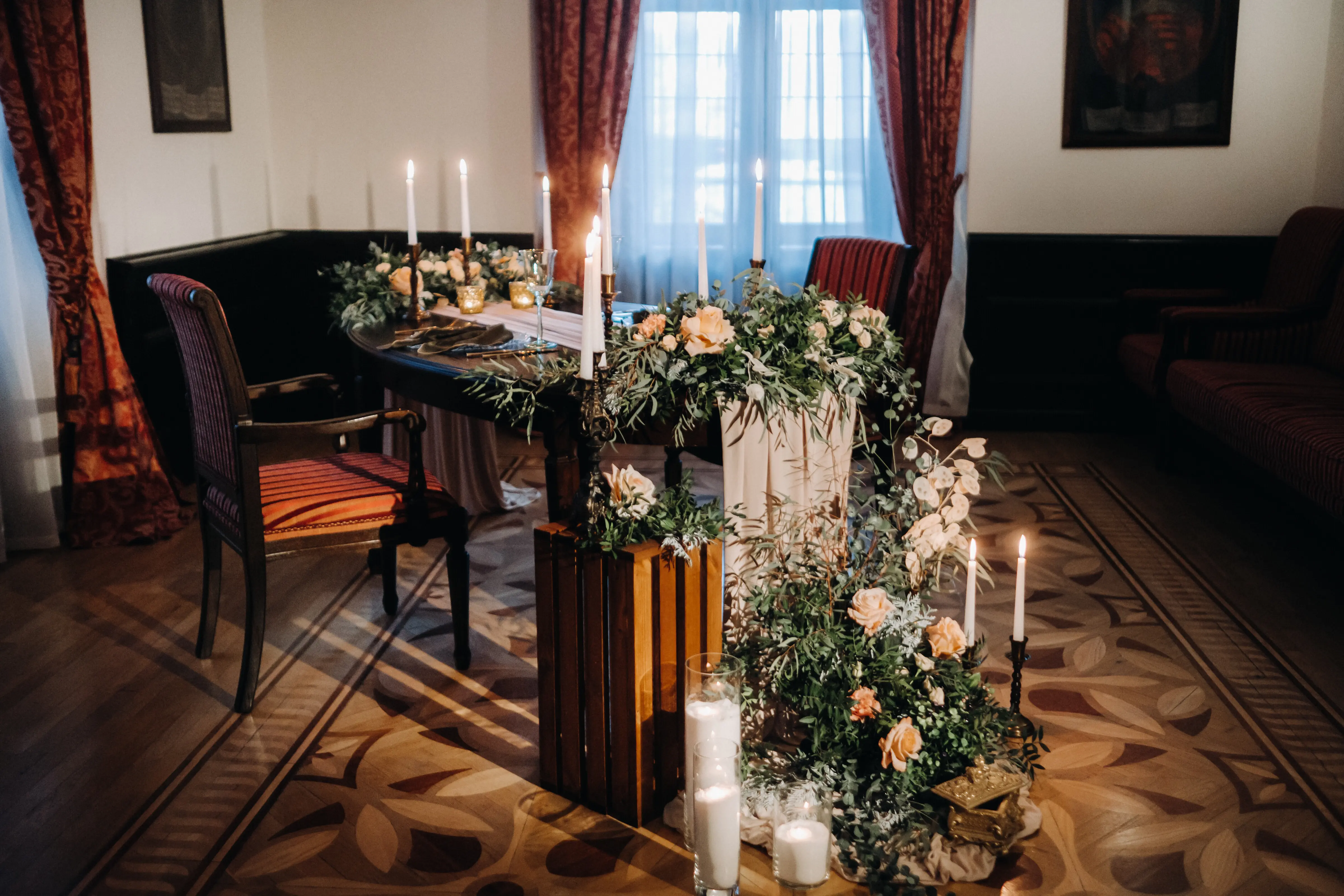 Hochzeitliche Tischgestaltung mit Blumen auf dem Tisch im Schloss, Dekor für ein Abendessen bei Kerzenschein. Abendessen mit Kerzen.